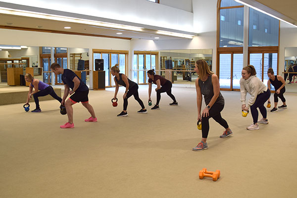 People holding kettleballs