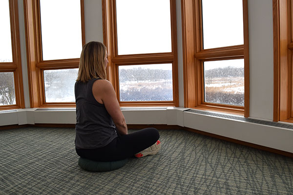 Woman sitting still looking out windows