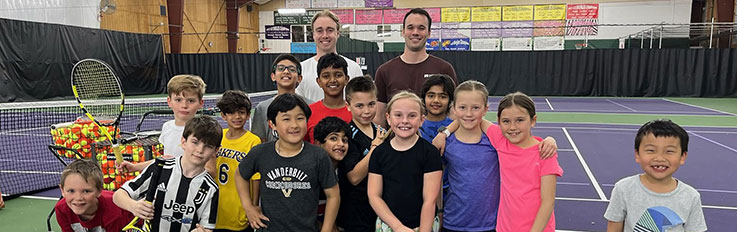 Large group of kids with tennis rackets