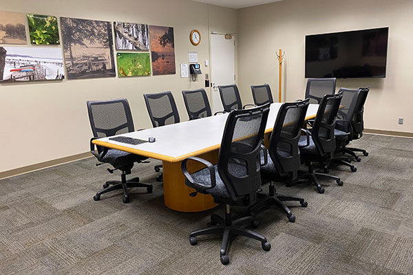 Room with conference table, chairs and TV screen