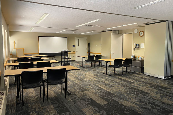 Room with multiple tables and chairs in classroom setting