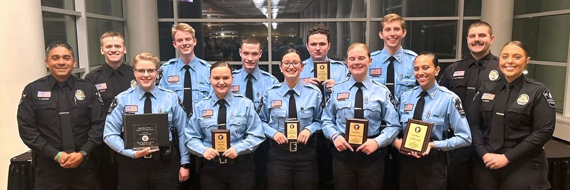 Teens standing in uniform with awards