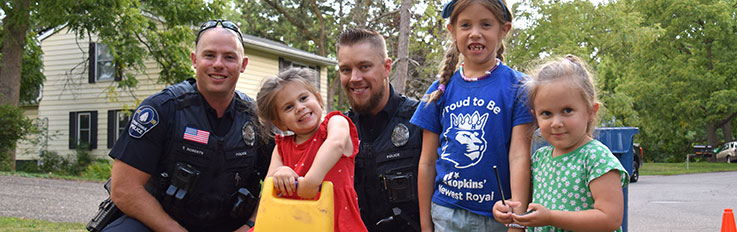 Two officers with little girls smiling