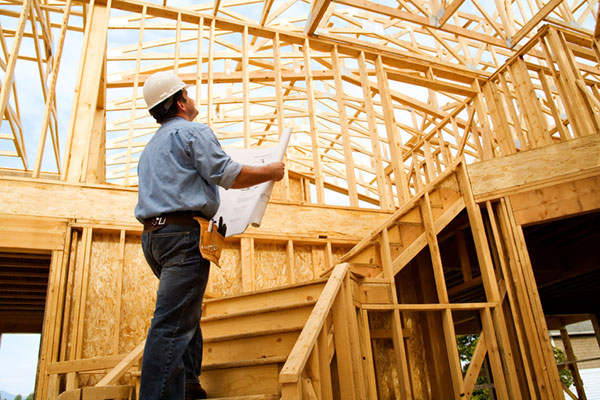 Construction worker looking at wood rafters