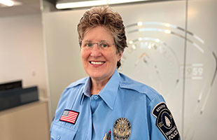 Woman in blue uniform smiling at camera