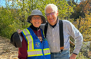 Man and woman outside in front of trees