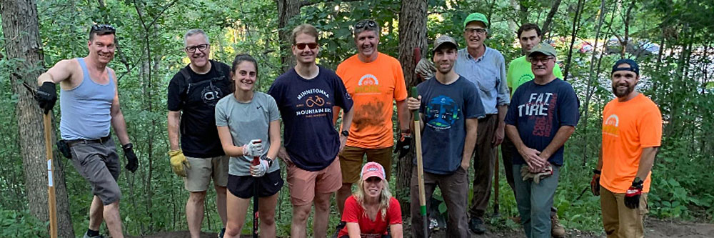 Large group of people posing around brush pile