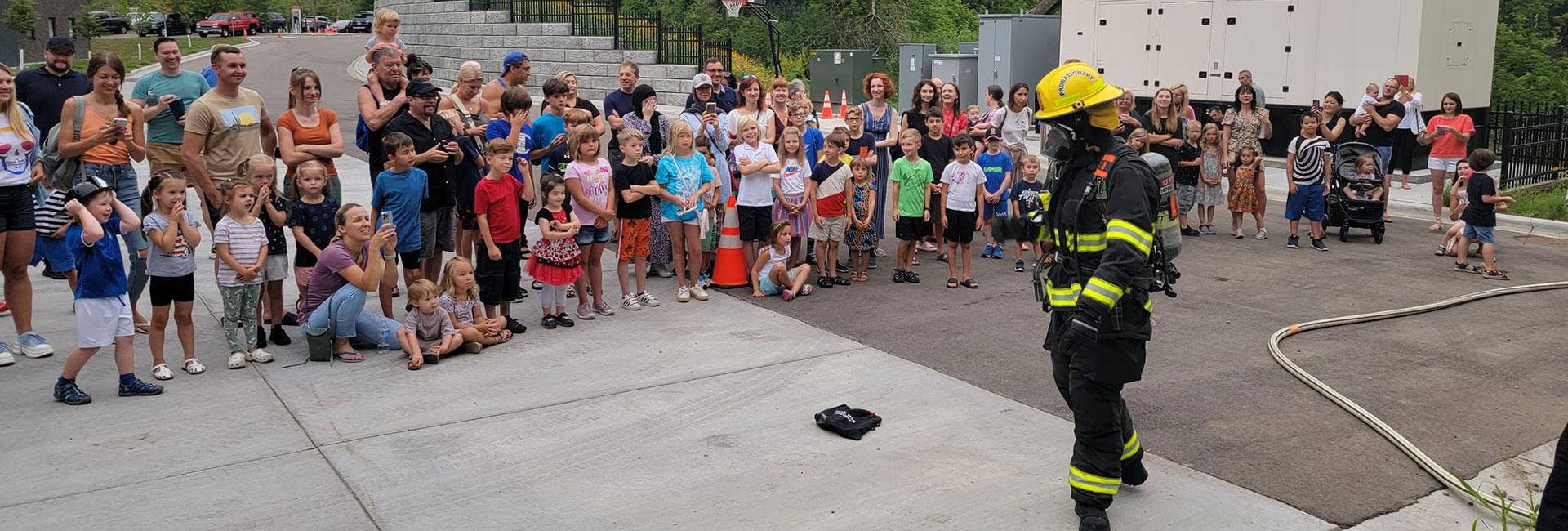 Large group of people watching a firefighter in uniform