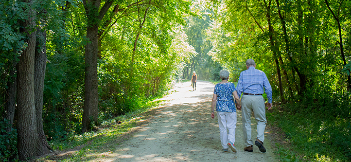 Older couple walking down a trail.